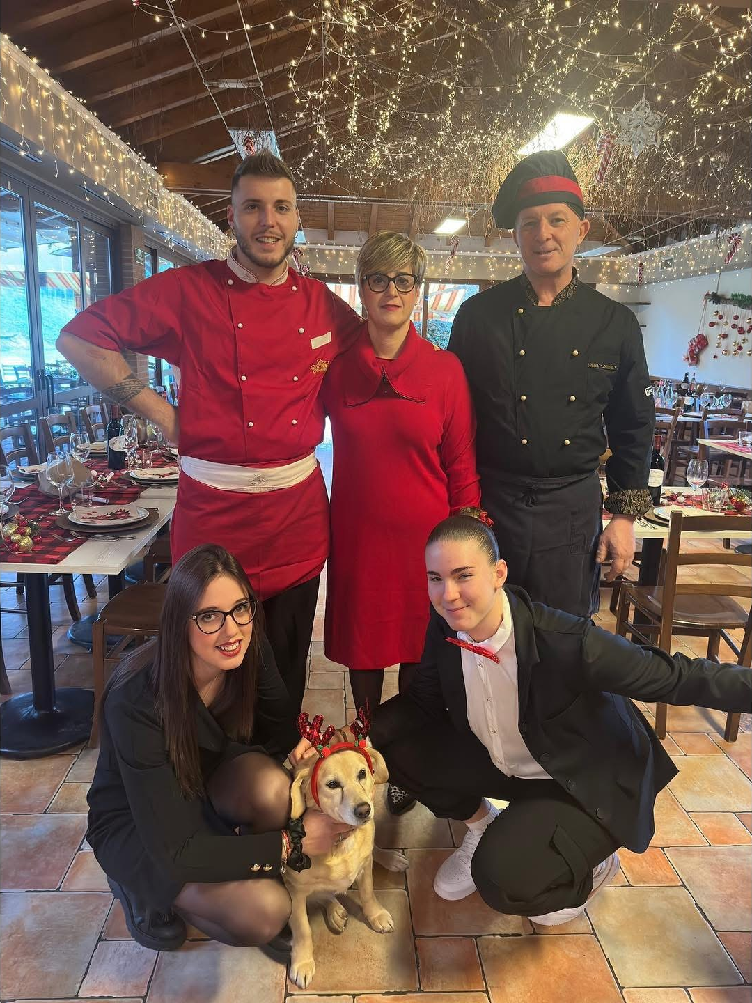 La famiglia al lavoro con il loro cane nella sala addobbata per le feste